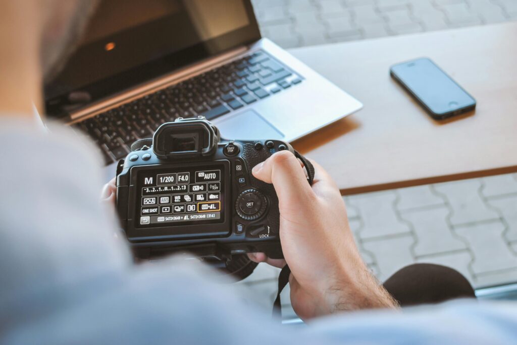 Content-Produktion vor Ort: Frau mit Kamera und Laptop bei einem individuellen Content-Tag für Website und Social Media.